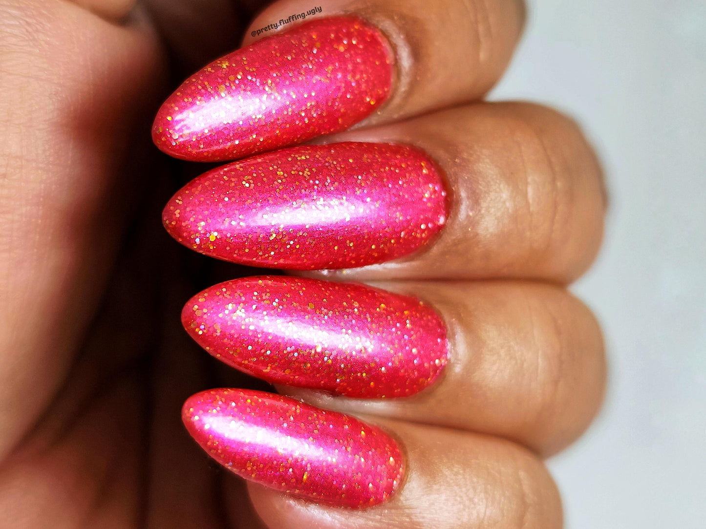 Hot Girl Summer swatch on dark skin tone – pink polish with gold sparkle