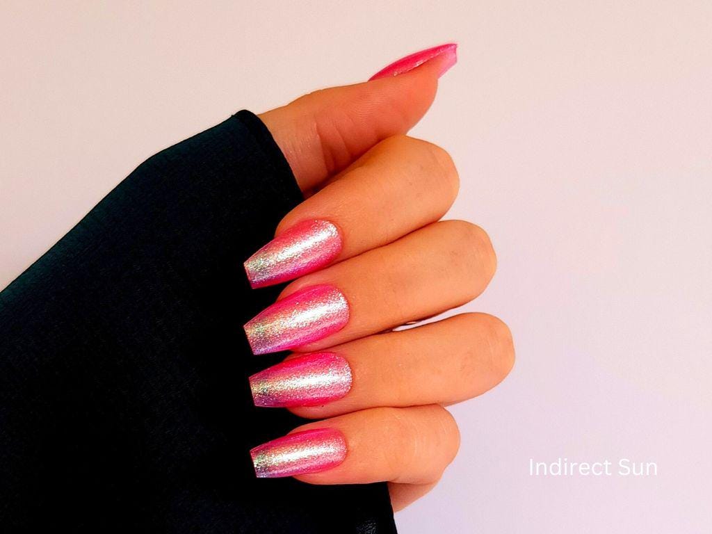 Sheer pink shimmer polish with multicolor shift on light skin – indie and buildable