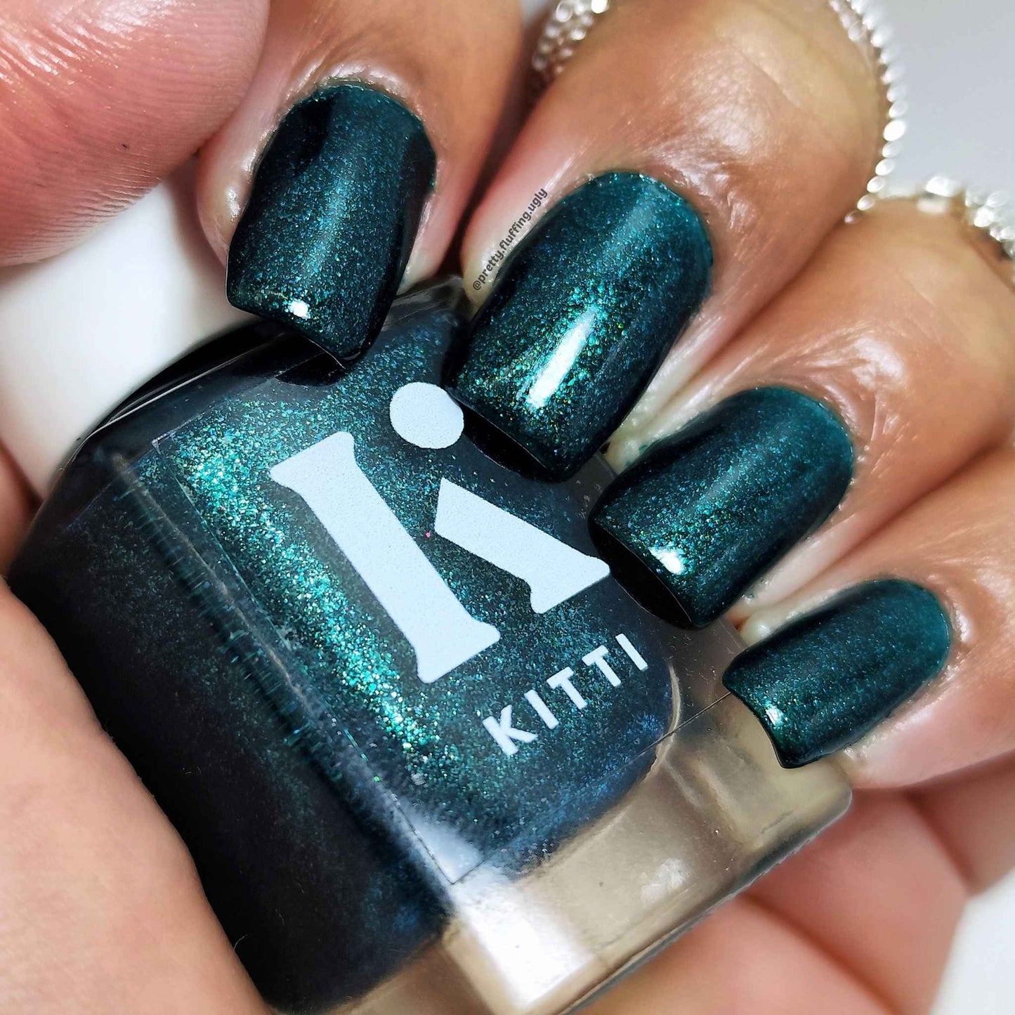 Glossy emerald green polish with glowy shimmer finish on dark skin tone