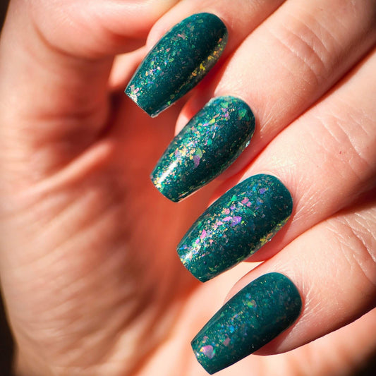 Nail polish with pink and blue flakes and gold shifting shimmer