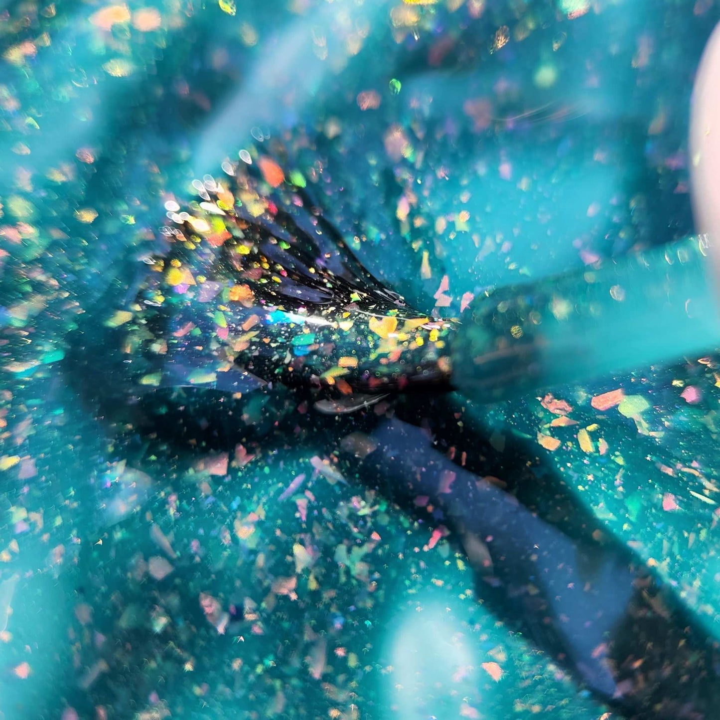 Witchy teal nail polish with shimmer and flakes