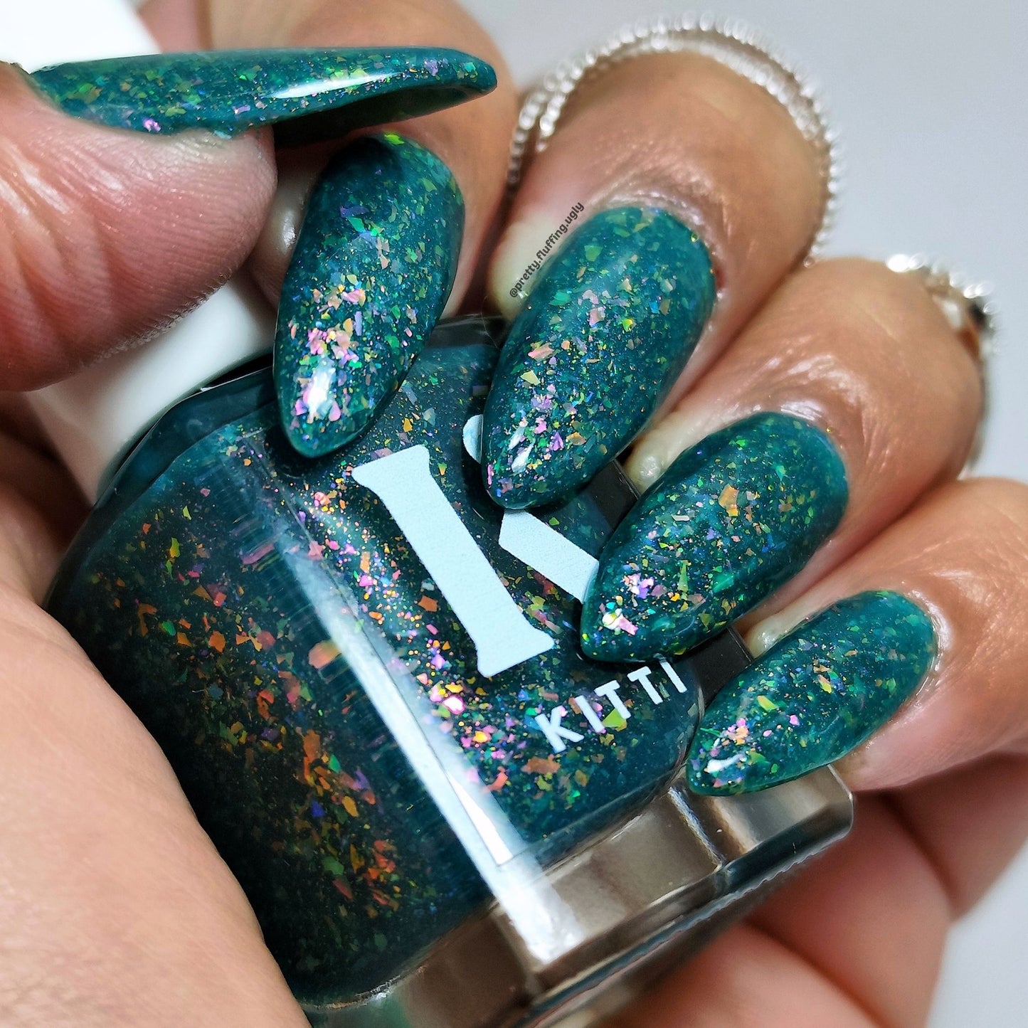 Cruelty-free flake polish with teal jelly base and shimmer