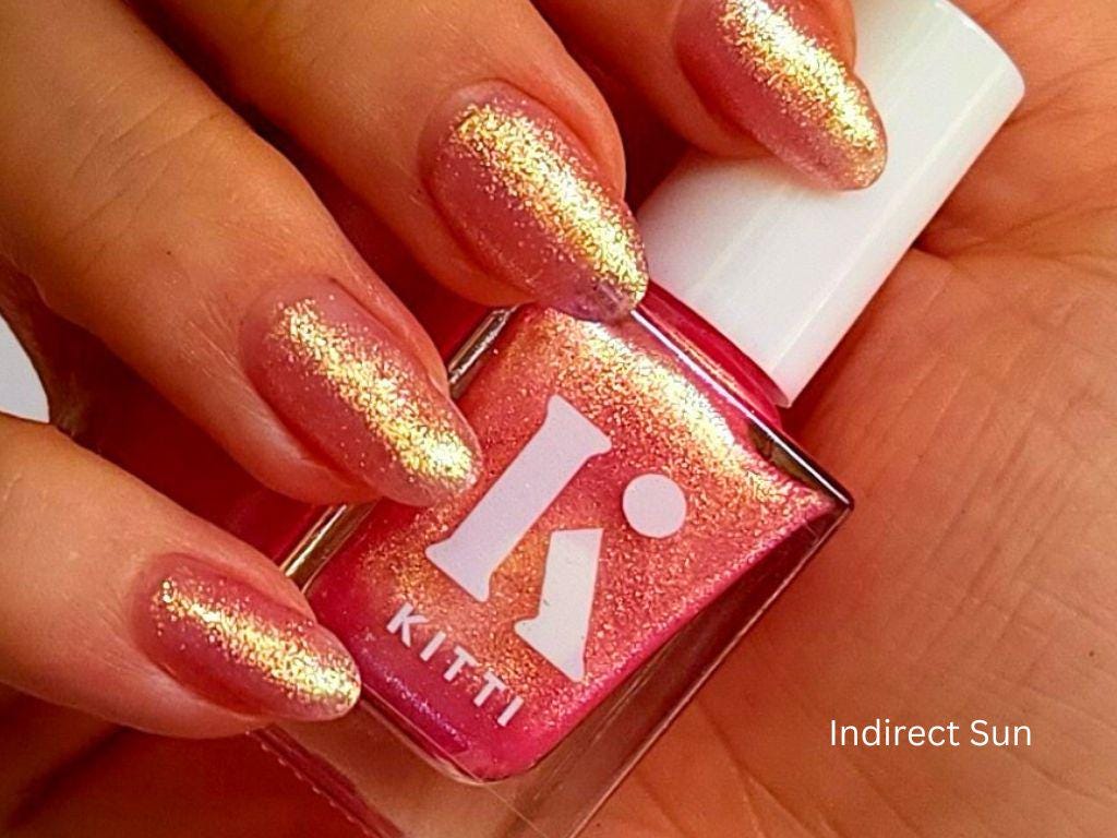 Subtle shimmer polish with green-gold shift – light skin tone swatch
