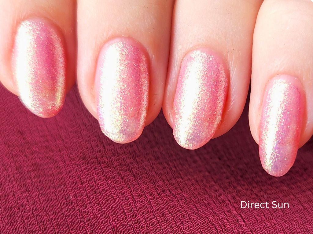 Macro of Glow Hard or Go Home – pink nail polish with gold-green shimmer particles