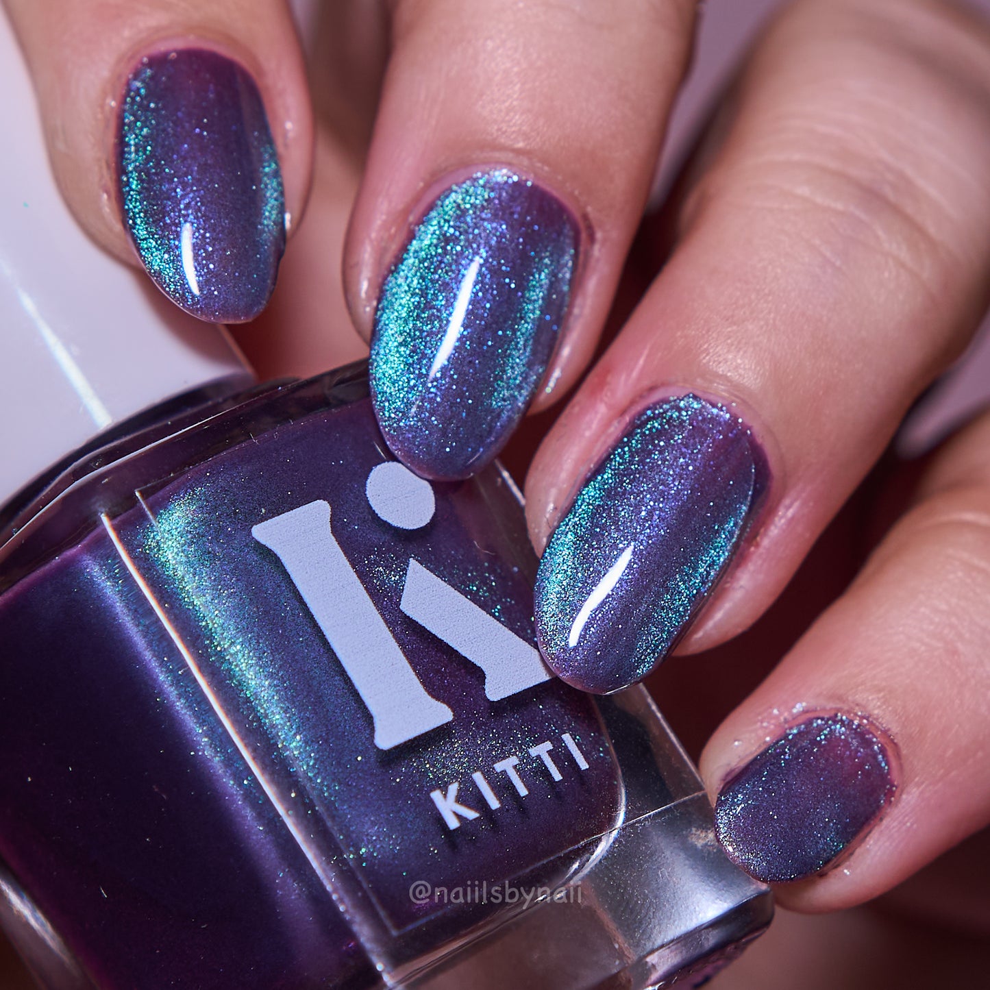 Kitti Nails Nail polish bottle, showcasing glittery purple and blue nail art.