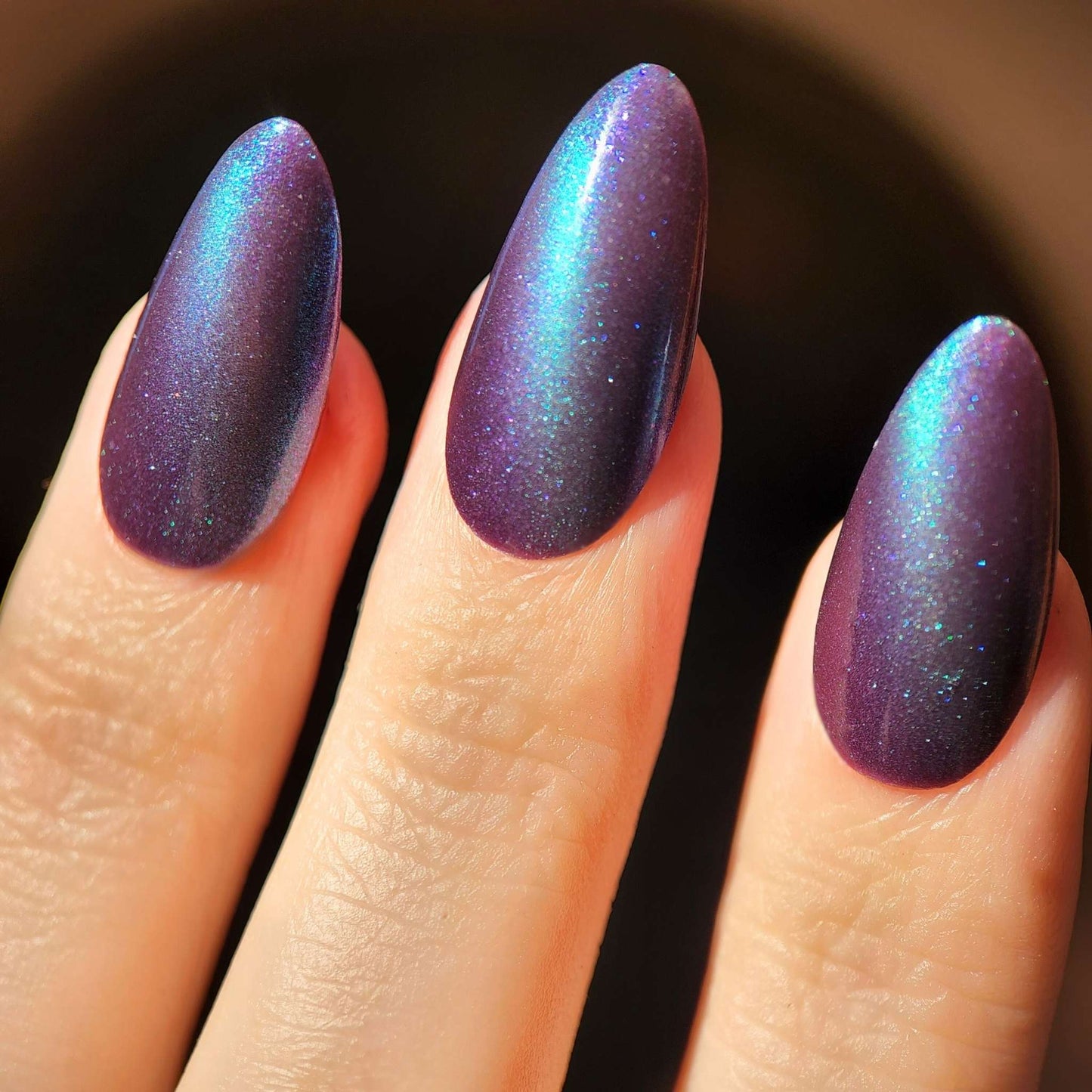 Vegan magnetic nail polish with purple base and blue shimmer