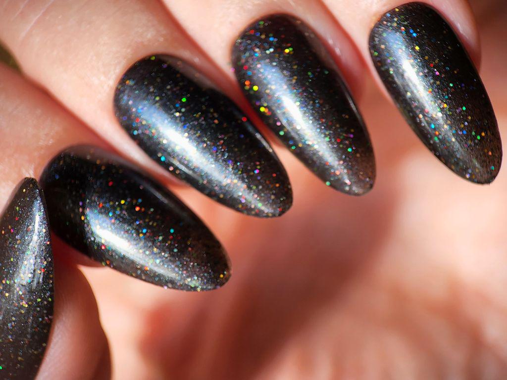 Black nail polish with rainbow glitter on light skin tone – Chaos Era swatch