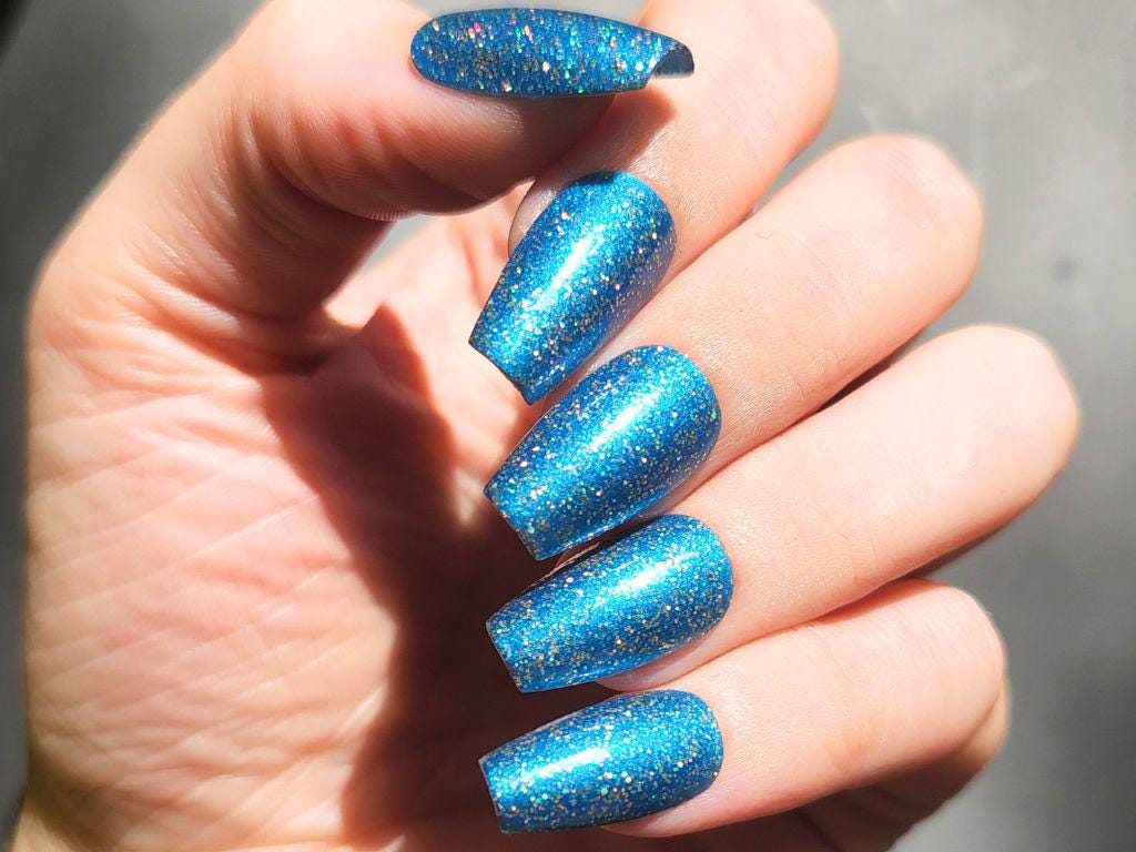 Deep navy nail polish with gold holographic glitter– opaque in 2–3 coats