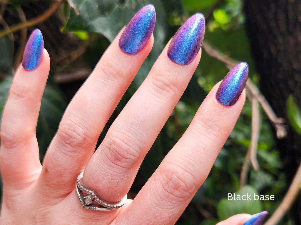 Glow Up over black nail polish – sheer peach with vibrant blue-purple shimmer pop
