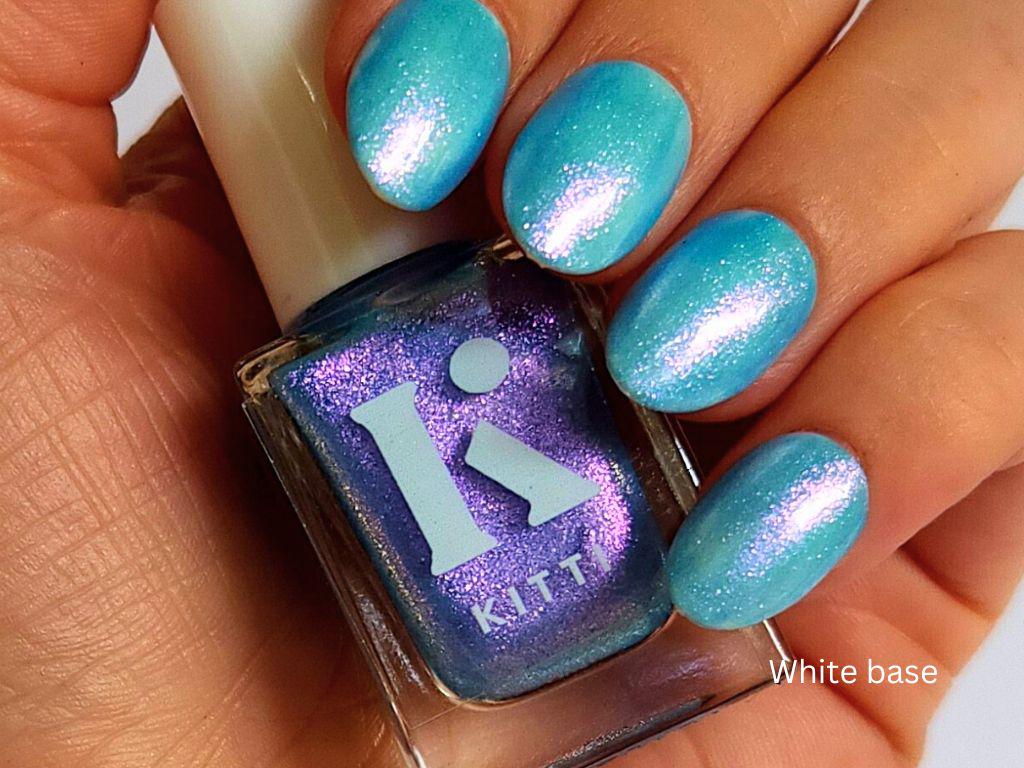 Glow & Tell over white polish – sheer blue topper with vibrant purple shimmer