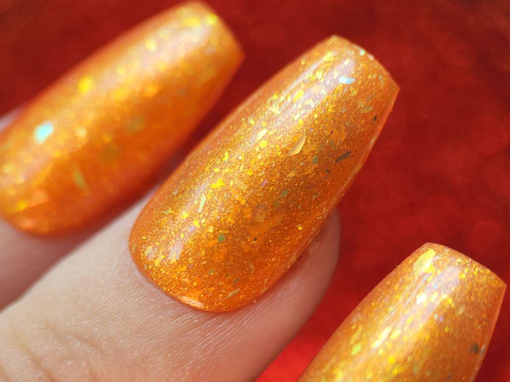 Macro of gold shimmer and flakes in orange jelly base – Kitti Nails