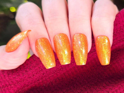 Orange jelly nail polish with gold shimmer on light skin – Here Comes the Sun