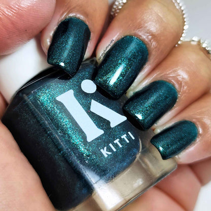 Glossy emerald green polish with glowy shimmer finish on dark skin tone