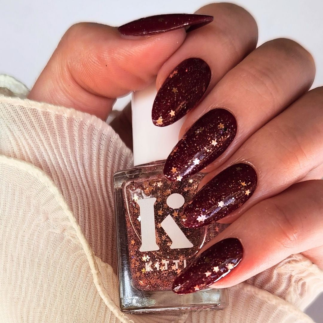 Champagne Popper topper swatched over Heather Potion deep shade showing buildable rose gold sparkle effect