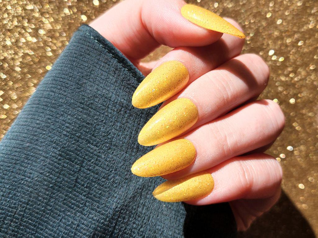 Bright yellow glitter polish on fair skin – non-toxic and quick-drying