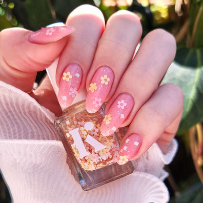 Close-up of nails with Petal Party topper – pastel daisy glitters over sheer pink base