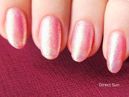 Macro of Glow Hard or Go Home – pink nail polish with gold-green shimmer particles
