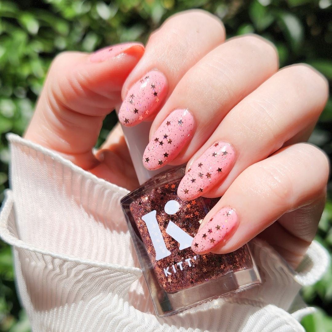 Champagne Popper rose gold glitter topper bottle with sparkly topper swatch over pink nails in sunlight