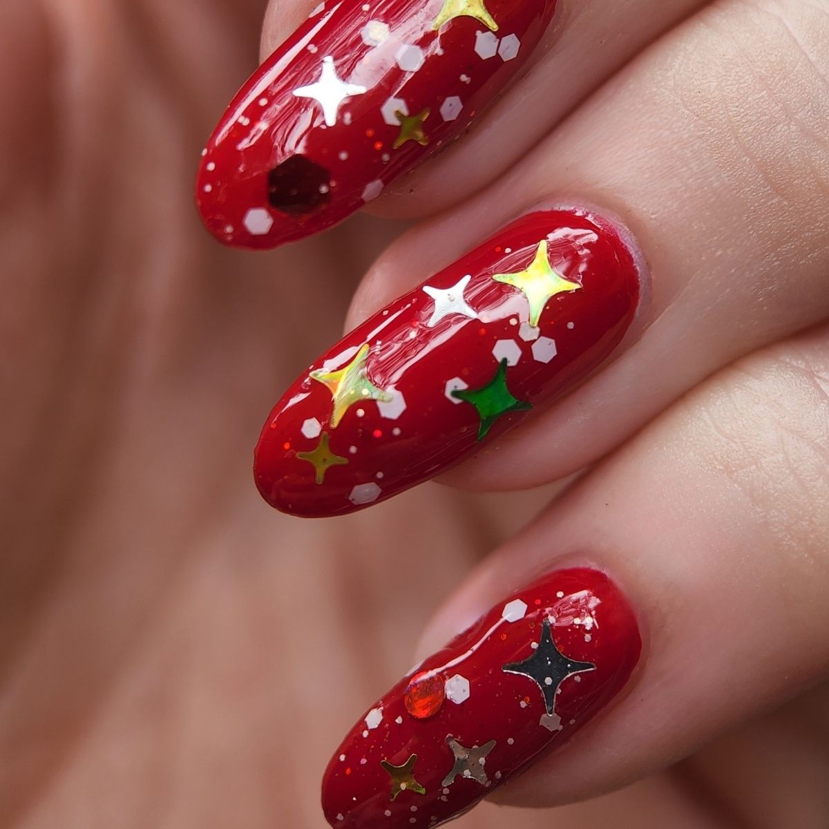 Close-up of Christmas nail art on long red nails 
