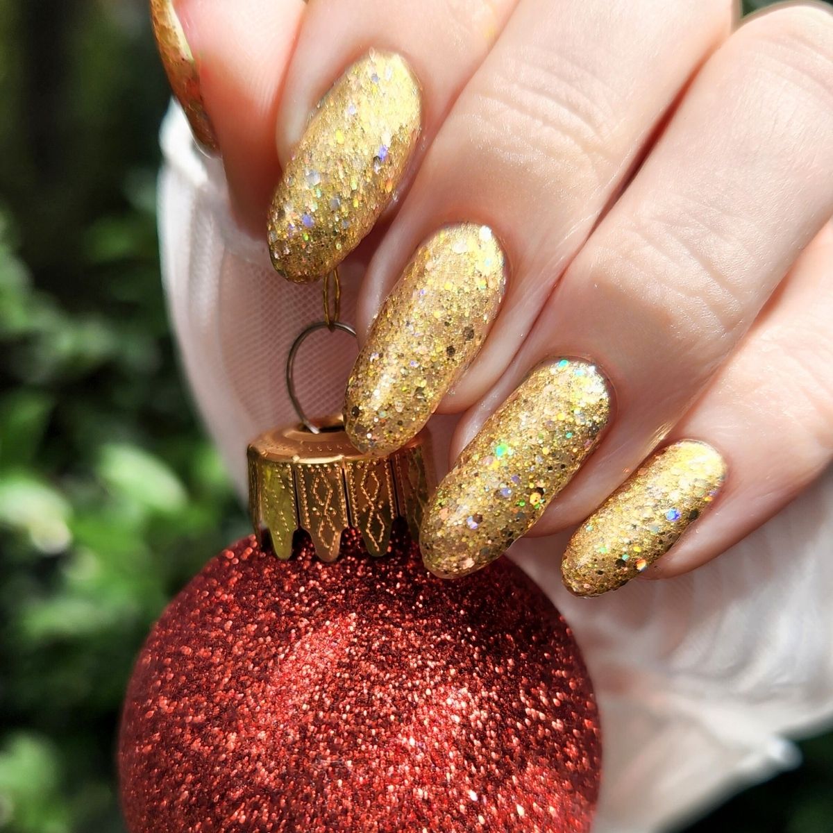 Red glittery christmas ornament with gold glittery nail design