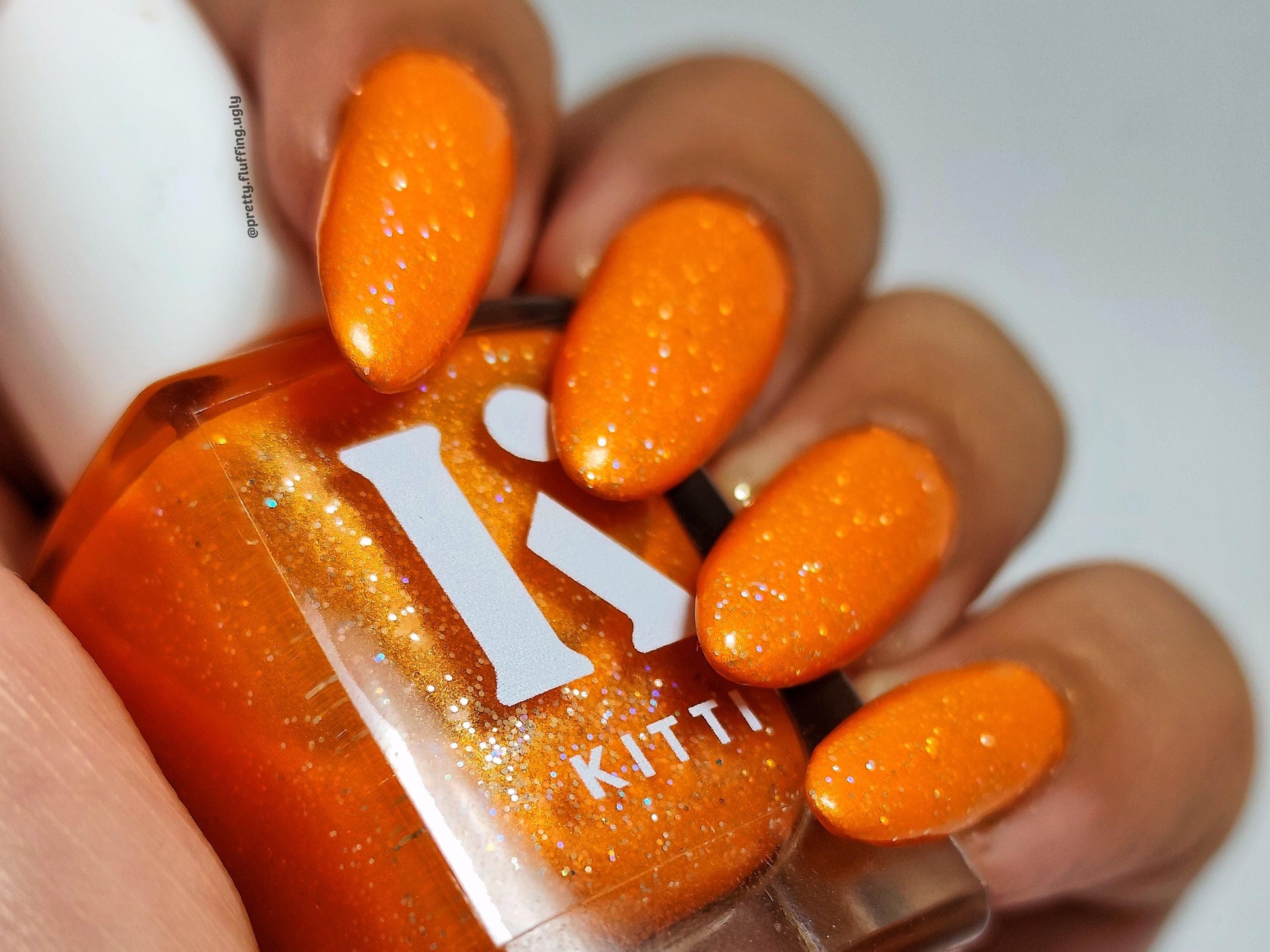 Full coverage orange glitter polish – swatched on dark skin tone
