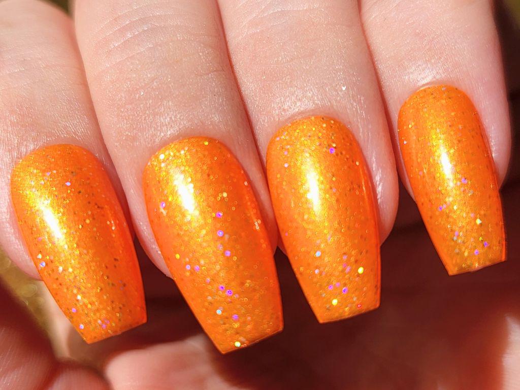 Macro shot of holographic glitter in orange polish – ultra sparkly indie shade