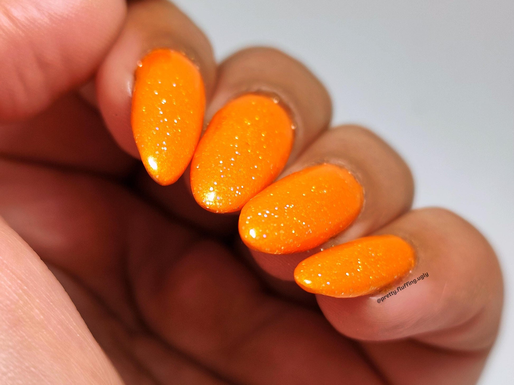 Opaque orange nail polish with holographic glitter – long-wearing and smooth finish